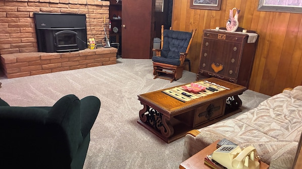 A living room with a fireplace, a wooden coffee table, a sofa, and a chair.