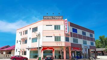 A multi-story hotel with a prominent sign reading 'HOTEL VOGUE HOTEL ROMANIN'.
