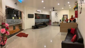 A hotel lobby with a reception desk, seating area, and a large flat-screen TV. - Vogue Rompin (Kuala Rompin)