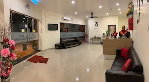A hotel lobby with a reception desk, seating area, and a large flat-screen TV. - Vogue Rompin (Kuala Rompin)