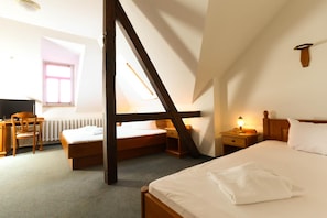 A bedroom with two beds, a desk, and a chair. - Parkhotel-forsthaus Dresden (Tharandt)