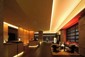A modern lobby with a reception desk, seating area, and bookshelves. - Yumanju Hotel (Guangzhou TaiKoo Hui Tianhe Stadium Flagship Store) (Guangzhou)