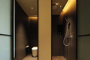 A modern bathroom with a toilet, a shower, and a glass partition. - YOMANJO (Guangzhou)