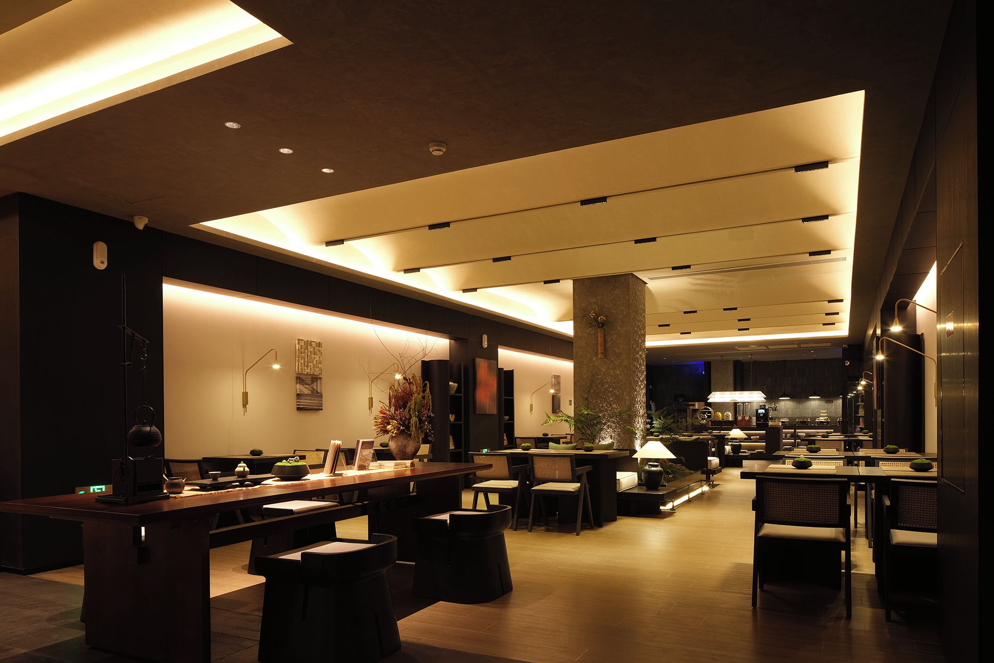A modern hotel lobby with a reception desk, seating area, and a bar.