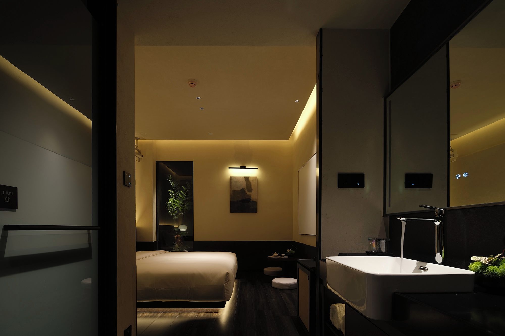 A modern bathroom with a large mirror, a sink, and a toilet.