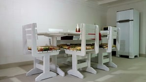 Une petite cuisine équipée avec un réfrigérateur blanc et une table avec des chaises.
