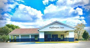 Un Hotel Hallmarc con zona de estacionamiento techada y un edificio de un piso.