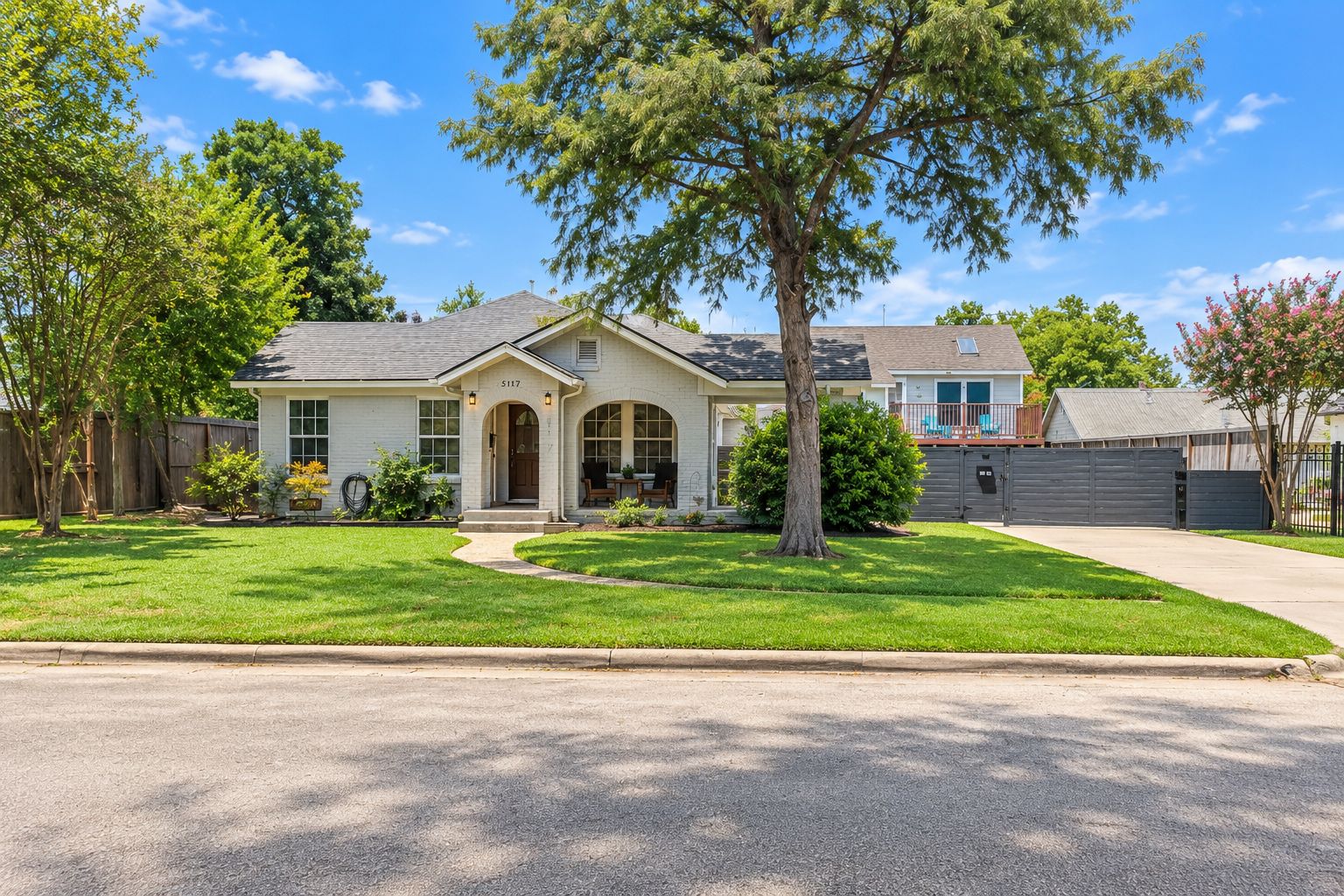 A single-story house with a front porch, a garage, and a well-maintained lawn.