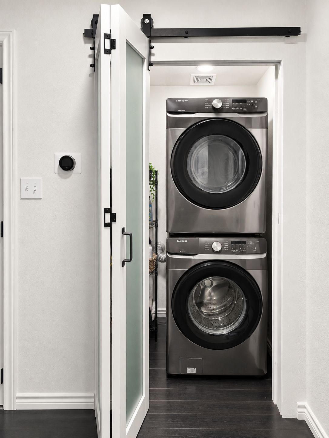 A laundry room with two stacked front-loading washing machines.