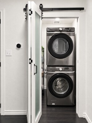 Una sala de bugaderia amb dues rentadores superposades.
