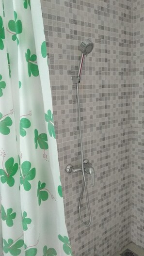 A shower with a handheld showerhead and a wall-mounted faucet. - Uni Inn Semarang Gunung Pati Akbid Abdi Husada (Semarang)