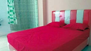 A room with a bed, a shower, and a curtain with a pattern. - Uni Inn Semarang Gunung Pati Akbid Abdi Husada (Semarang)