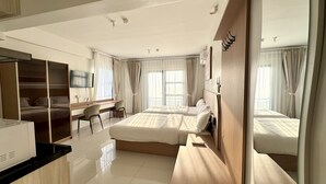 Una camera d'albergo con un letto, una scrivania, una sedia e una televisione.