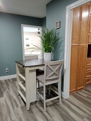 A room with a desk, chair, potted plant, and wooden wardrobe. - Private 3-bedroom guest suite for up to 6 guests featuring a full kitchen, comfortable living space, private entrance, and swimming pool. Enjoy a peaceful, gated setting with convenient access to Conroe, The Woodlands, shopping, dining, hospitals (Conroe)