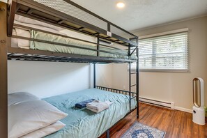 A bunk bed room with a window and a radiator. - The Buttonwood Retreat Game Room Fire Pit (Tobyhanna)