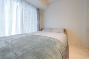 A bedroom with a bed, a window with curtains, and a light-colored floor. - unito residence SHINSAIBASHI East (Chuo-ku,)