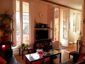 A living room with a television, bookshelves, a coffee table, and a potted plant. - Barcelona Central Garden (Barcelona)