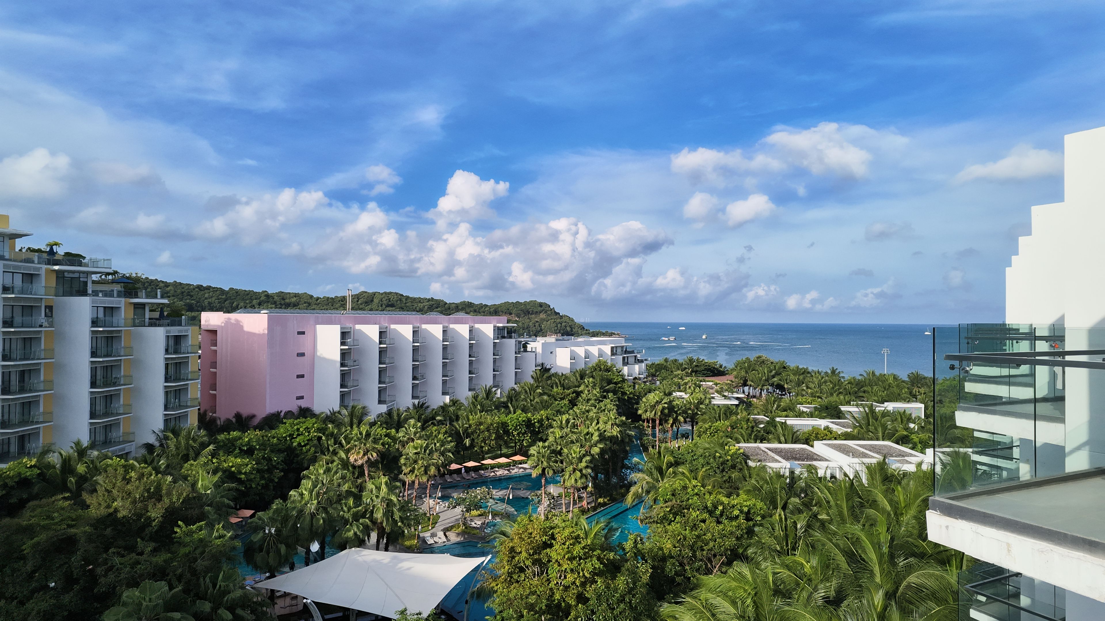 Um resort com vários edifícios, piscina e vista para o mar.