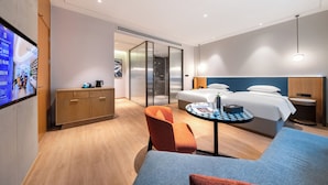 A modern hotel room with a bed, a desk, a chair, and a television on the wall. - Meihua Lizhi Hotel (Hangzhou)