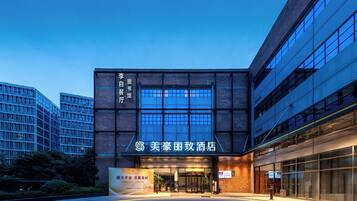 A hotel entrance with a modern facade, large glass windows, and a prominent sign.