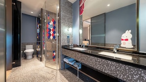A modern bathroom with a glass shower enclosure, a large mirror, and a vanity with a sink. - Meihua Lizhi Hotel (Hangzhou)