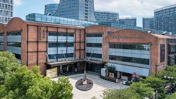 Un edificio moderno con facciata in vetro e sezione in mattoni, con insegna dell'hotel 'MEHOOD LESTIE'.
