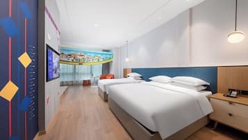 Una habitación de hotel con una cama grande, mesitas de noche, un escritorio y un televisor instalado en la pared.