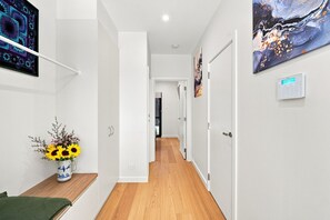 A hallway with a wooden floor, white walls, and a door at the end. - Modern 2BR Townhouse | Coastal Views, Double Garage & Steps to the Beach (Victor Harbor)