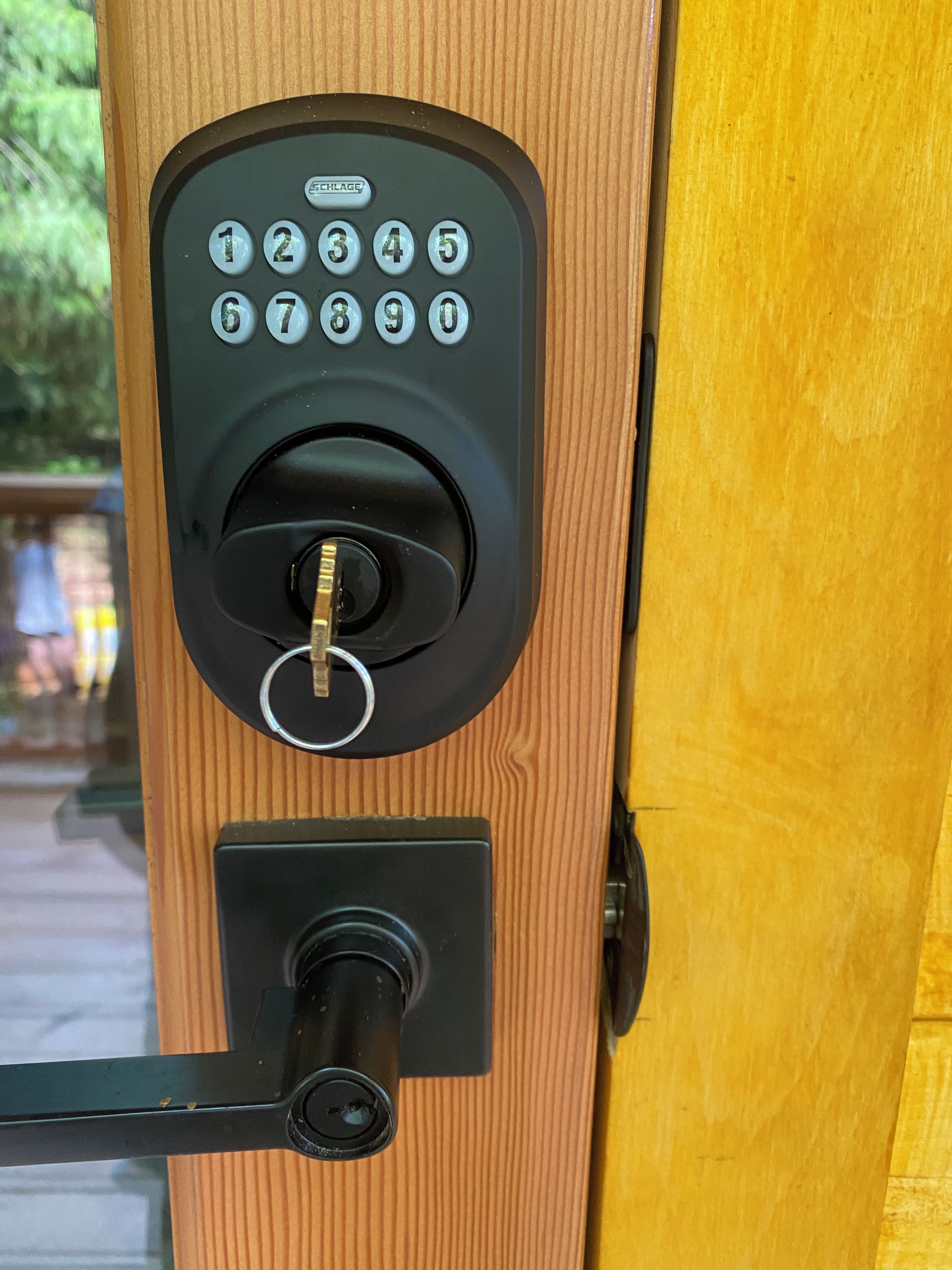 A keypad lock on a wooden door.