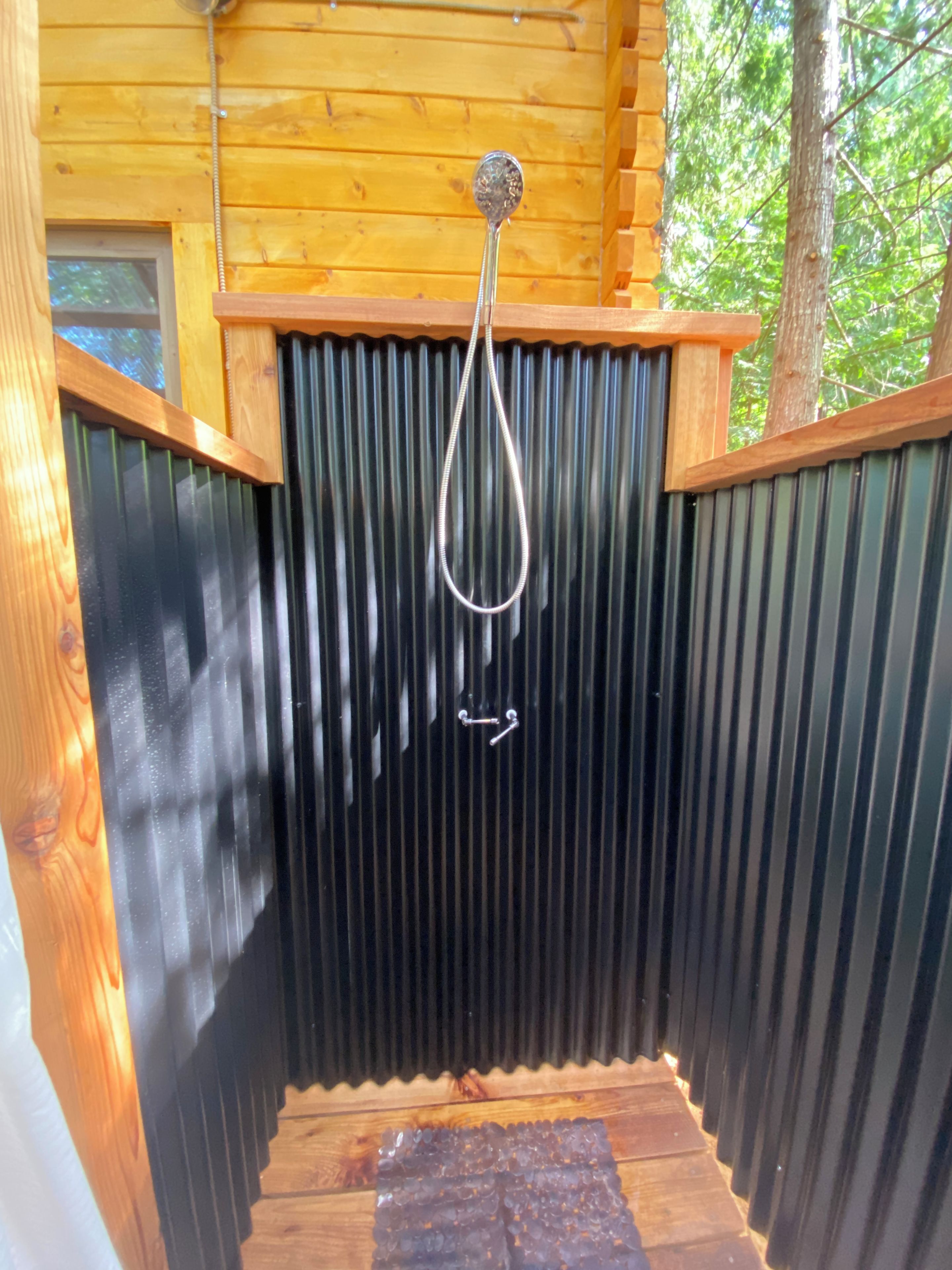 Une cabane en bois avec une porte en métal et une poignée en métal.