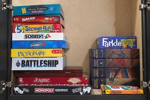 A collection of board games stacked in a cabinet.
