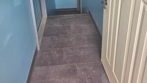 A hallway with a door on the right and a window on the left.