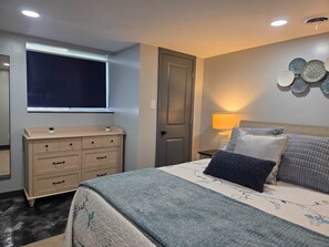 Ein Schlafzimmer mit Bett, Kommode, Fenster, Tür und Wanddekoration.