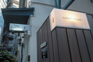 Un edificio con un letrero que indica 'Tokyo Candle House' y un letrero que dice 'GUEST HOUSE'.