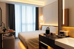 A hotel room with a bed, bedside table, lamp, and a large mirror. - SSAW Boutique Hotel Shenzhen Snow World (Shenzhen)