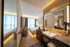 A modern hotel room with a bed, bedside table, lamp, and a large mirror. - SSAW Boutique Hotel Shenzhen Snow World (Shenzhen)