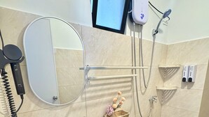 A bathroom with a toilet, sink, mirror, and a shower. - Royal Oceancrest Panglao 1 (Dauis)