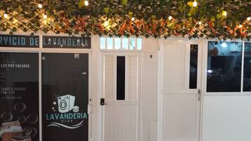 A storefront with a sign for 'LAVANDERIA VIVE' and a closed door.