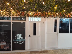 A storefront with a sign for 'LAVANDERIA VIVE' and a closed door.