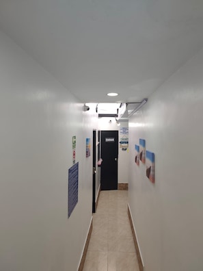 A hallway with a door labeled 'DESARENADOR' and a sign indicating a check-in time of 5:00 AM.