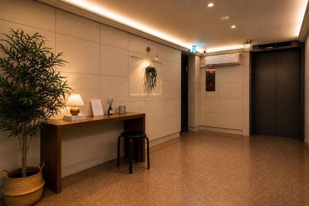 Eine Hotelhalle mit einer Rezeption, einem Blumentopf, einer Wandpflanze und einem Aufzug.