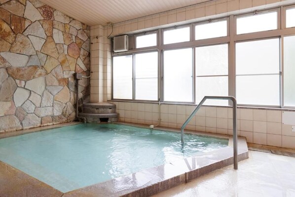 An indoor swimming pool with stone walls and large windows. - KKRShirahamamihamasou (Shirahama)