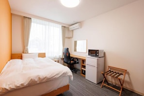 A hotel room with a bed, desk, chair, and a small refrigerator. - KKRShirahamamihamasou (Shirahama)