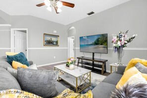 Ein Wohnzimmer mit einer Couch, Couchtisch, Fernseher und Dekoration.