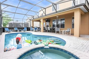 An indoor swimming pool with lounge chairs and a covered seating area. - 7BR Windsor Hills Heated Pool Game Room NearDisney (Kissimmee)