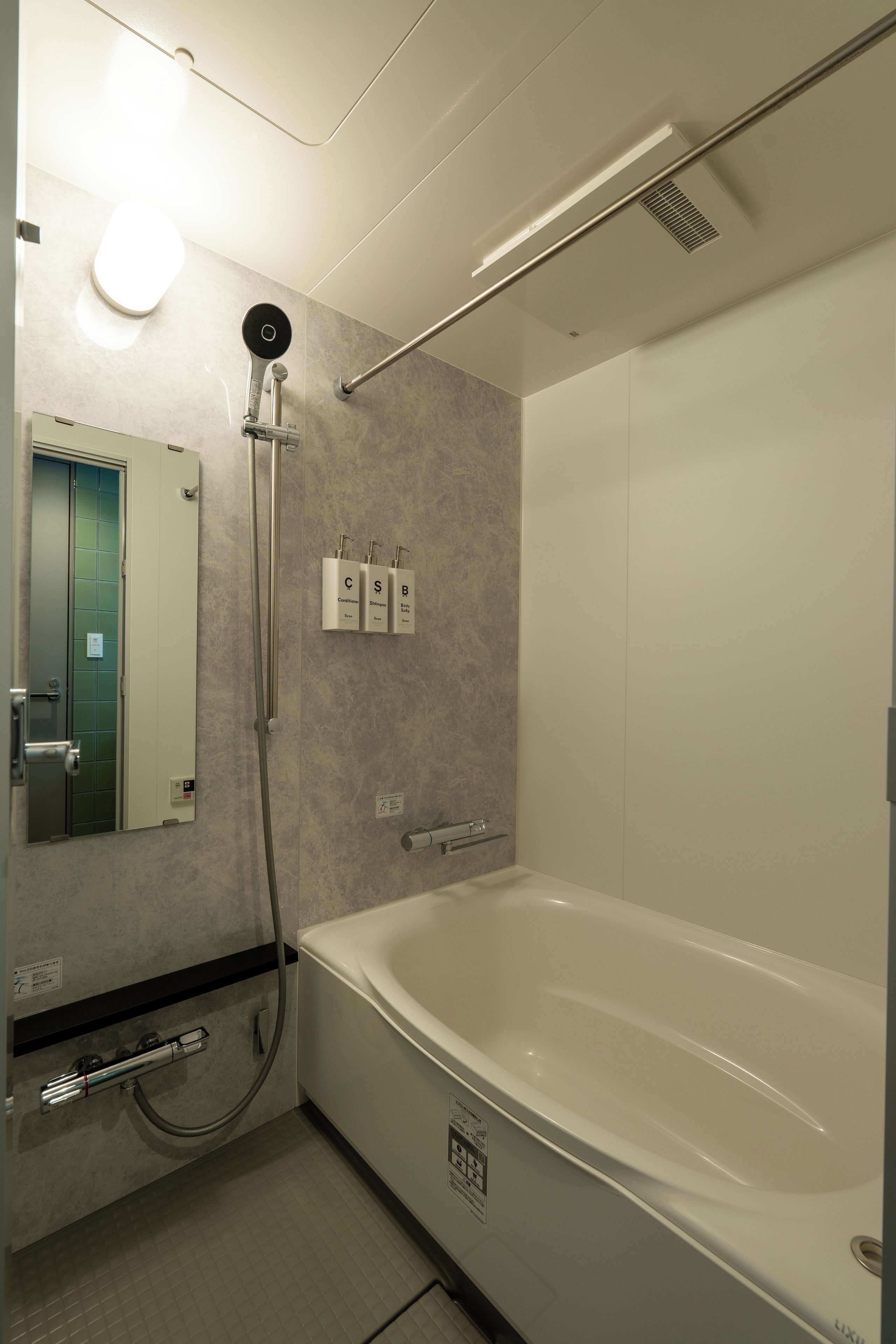 Un baño moderno con bañera, ducha y espejo.
