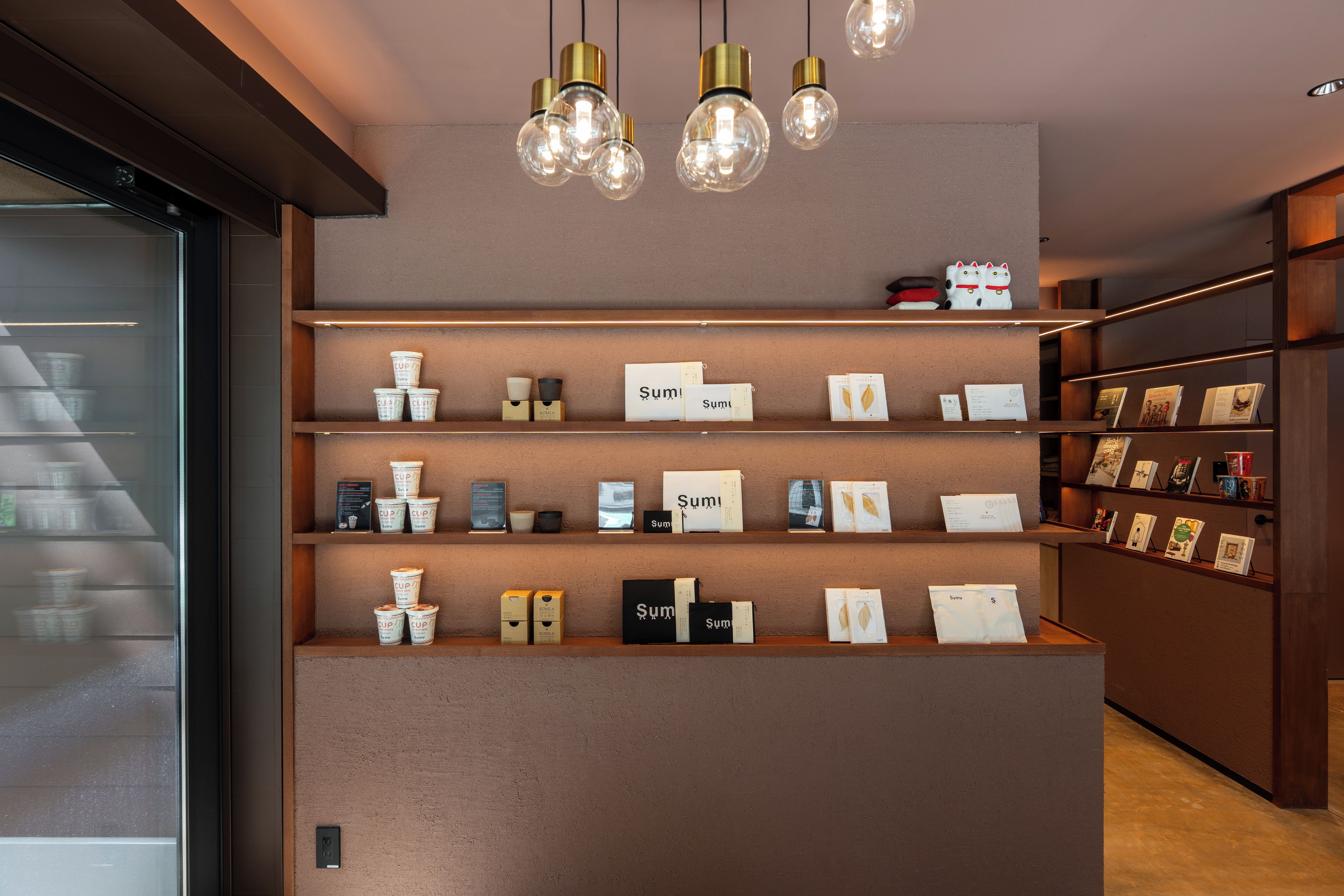A modern interior with a central display of products, shelves with books, and a glass-fronted display case.