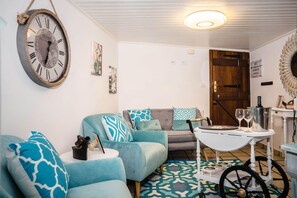 A cozy living room with a sofa, a coffee table, and a decorative clock. - Casa a Boleriã±a 1 (Poio)
