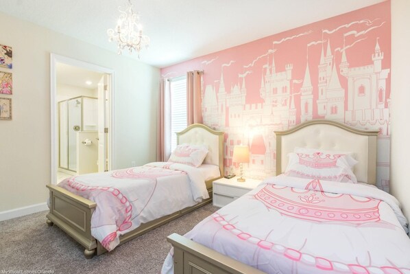 Quarto com duas camas, um candelabro e uma parede com tema de castelo.