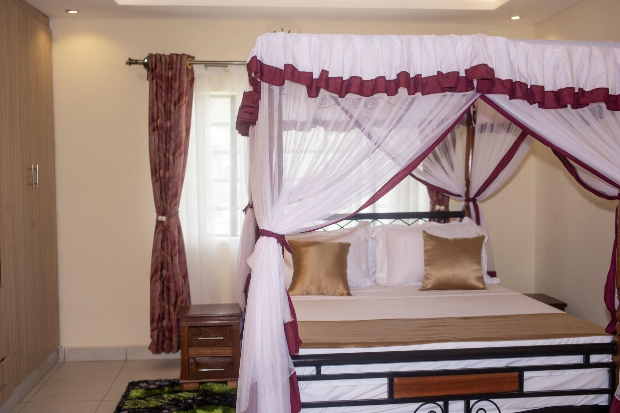 A four-poster canopy bed with a wooden frame and a mattress with two pillows.